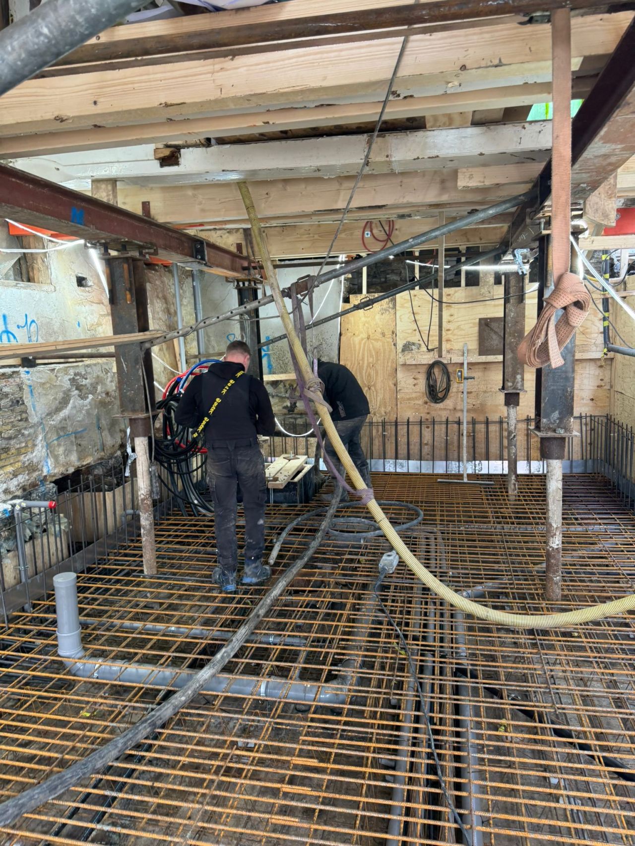 Wapening en leidingen voorbereid voor betonvloer bij kelderbouw in Amsterdam